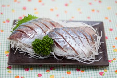 Dilimlenmiş tuzlu ringa balığı ve otlar. 