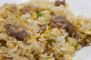 Lezzetli pirinç, et ve sebzeli beyaz tabak.