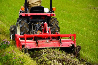 Tarlada traktörde çalışan bir adam..
