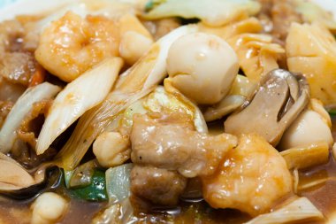 Lezzetli Asya yemeklerini yakından görmek, kızarmış deniz ürünlerini karıştırmak.