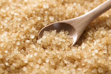 Esmer şeker ve tahta kaşık arka planda, kapatın.