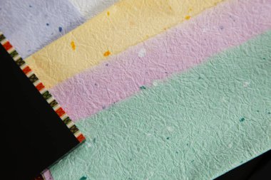 Renkli katmanlar halinde düzenlenmiş çeşitli desenli kağıtlar.