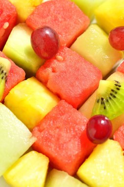 Taze meyve salatasını karpuz, ananas, üzüm ve kiviyle kapatın. 