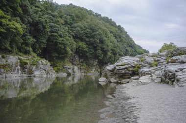 Kayalık kıyıları olan güzel bir nehir manzarası.