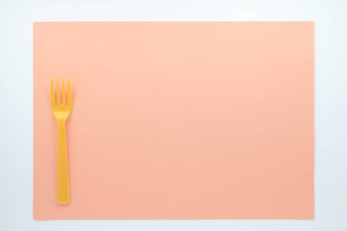 Turuncu plastik çatal bej arkaplanın üst görüntüsü       