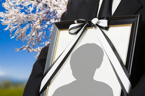 stock image Close-up view of person holding funeral frame with man silhouette 