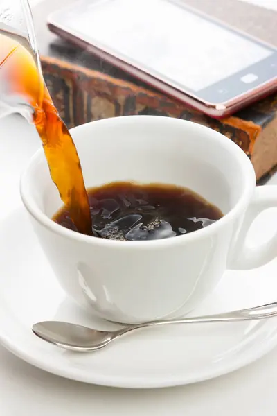 cup of coffee, book and phone on white table background, close-up view