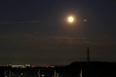 Gece manzaralı şehir ve ay karanlık gökyüzünde          