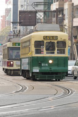 Hareket eden tramvayların yer aldığı sokak fotoğrafı.