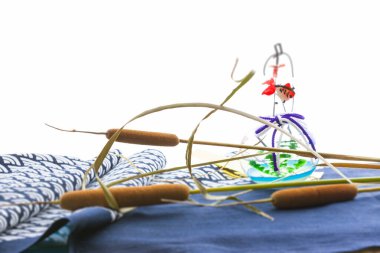 Kumaştaki renkli dekoratif öğelerin yanına dizilmiş tırmık kuyrukları