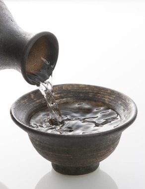 Japon sake 'sini şişeden killi fincana dök