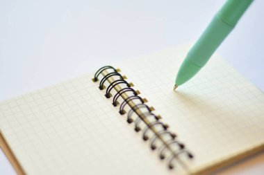 Işık arkaplanındaki kalem ve defterin yakın plan görüntüsü     