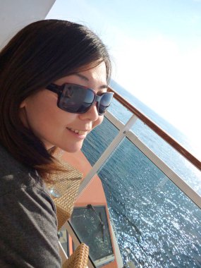 Sevimli Asyalı kadın gemiyle seyahat ediyor.