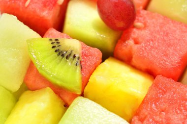 Taze meyve salatasını karpuz, ananas, üzüm ve kiviyle kapatın. 