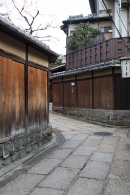 Geleneksel ahşap binalar arasındaki dar taş sokak.