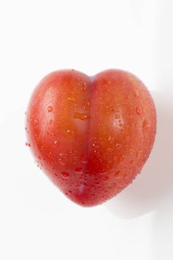 Heart-shaped red apple with droplets