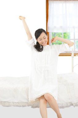 Asyalı kadın yatakta uyanıyor.