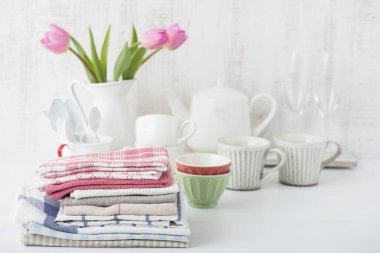 set of clean napkins, table ware, tulips in vase on kitchen table