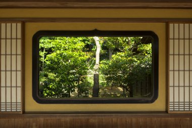 Geleneksel Japon evi penceresi ve güzel bahçe manzarası.  