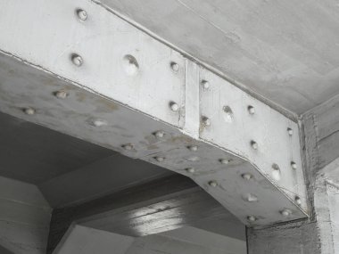 Yakın plan, beton tavan yapısını destekleyen endüstriyel çelik kirişi gösteriyor