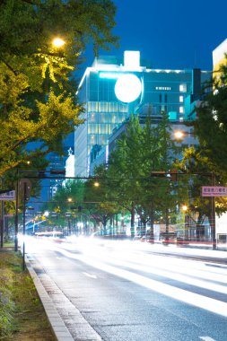 Aydınlatılmış şehir caddesinde akşam saatlerinde bulanık araba ışıkları