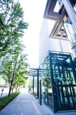 Şehirde yeşil ağaçları olan modern bir bina. 