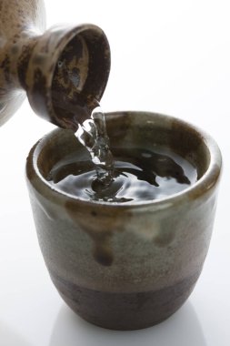 Japon sake 'sini şişeden killi fincana dök