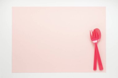 Bej arkaplanda parlak plastik çatal bıçak takımının üst görünümü                