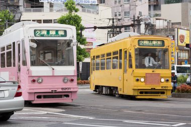 Hareket eden tramvayların yer aldığı sokak fotoğrafı.