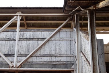 Kırsal sanayi binasını destekleyen yıpranmış ahşap kirişler.