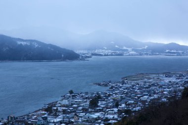 Karla kaplı dağlar ve kışın göl manzarası