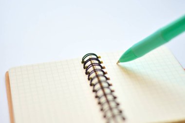 Işık arkaplanındaki kalem ve defterin yakın plan görüntüsü     