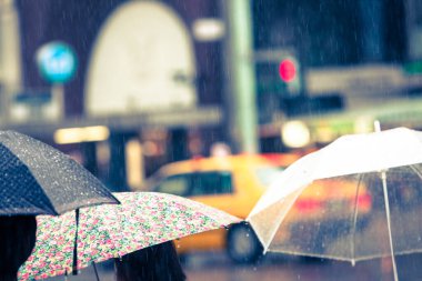 Büyük şehrin sokaklarında şemsiyeli insanlar var..                     