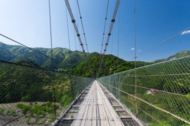 Nehrin üzerindeki güzel dağlarda kablo köprü.