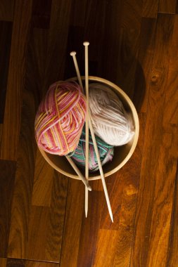 Masada örgü iğneleri ve iplik toplarının olduğu bir stüdyo fotoğrafı. 