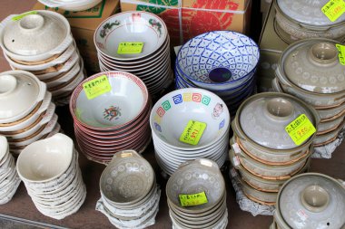 Renkli kaseler ve tabaklar öğlen güneşinde yerel bir markette satışa sunuldu.