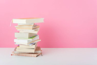 Masa pembe arka planda bir yığın kitap