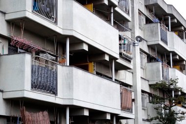 Birden fazla balkon ve parmaklıklı beton bina.
