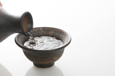 Japon sake 'sini şişeden killi fincana dök