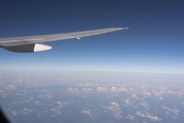 Gökyüzündeki bulutların üzerinde uçan bir uçağın kanadı. 