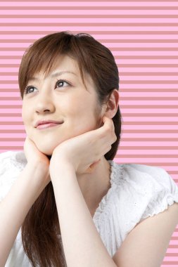 Beyaz elbiseli Asyalı kadın gülümsüyor.