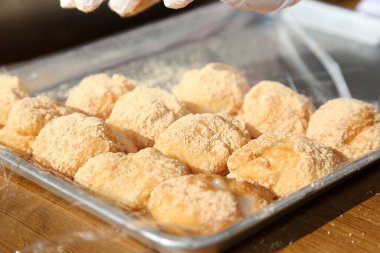 Bir tepsi taze pişmiş şeker kaplı hamur işi.