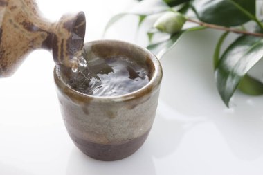 Japon sake 'sini şişeden killi fincana dök