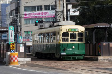 Modern şehir Japonya 'da gündüz tramvayı sokak sokak geziyor.