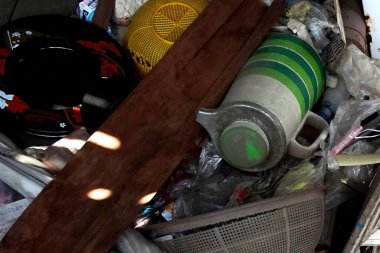 Ahşap kalaslar ve molozlar arasında çeşitli ev eşyaları var.