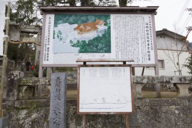 Tahta levhada kaplan çizimleri ve açık havada Japonca metinler var.