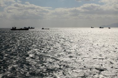 Gökyüzünde bulutlar ve gemilerle denize güzel bir manzara           