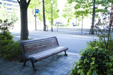 Kentte yeşil ağaçları olan modern bir bina. 
