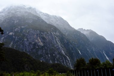 Şelaleli sisli dağların manzarası, gündüz manzarası. 