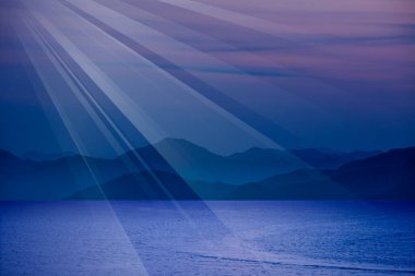 Deniz üzerinde gece ve arka planda dağlar.